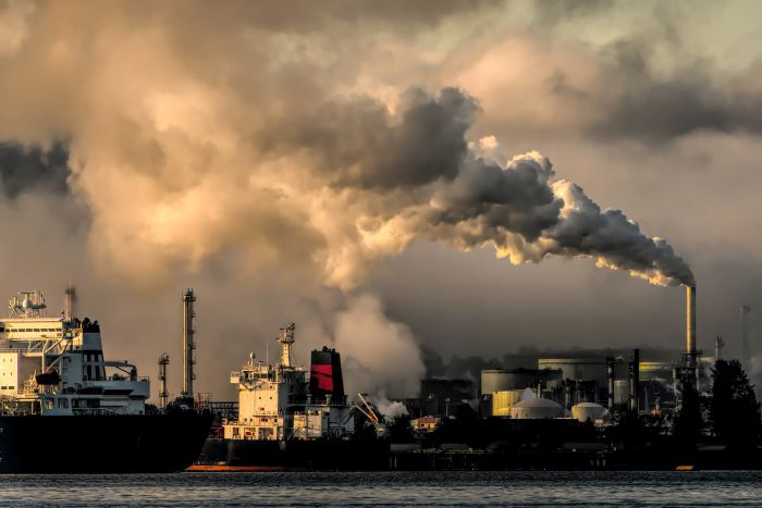 Harbor with a background of factories and dense smoke